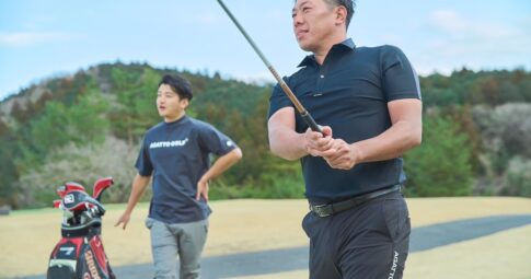 AGATTO GOLFのウェアでコースに立つ堀川未来夢プロと男性ゴルファー