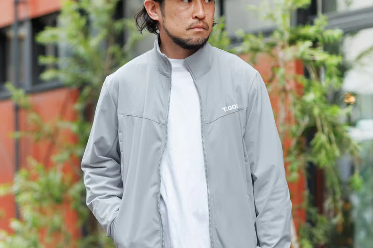 KINASHI CYCLE GOLFのグレーブルゾンを着用した男性