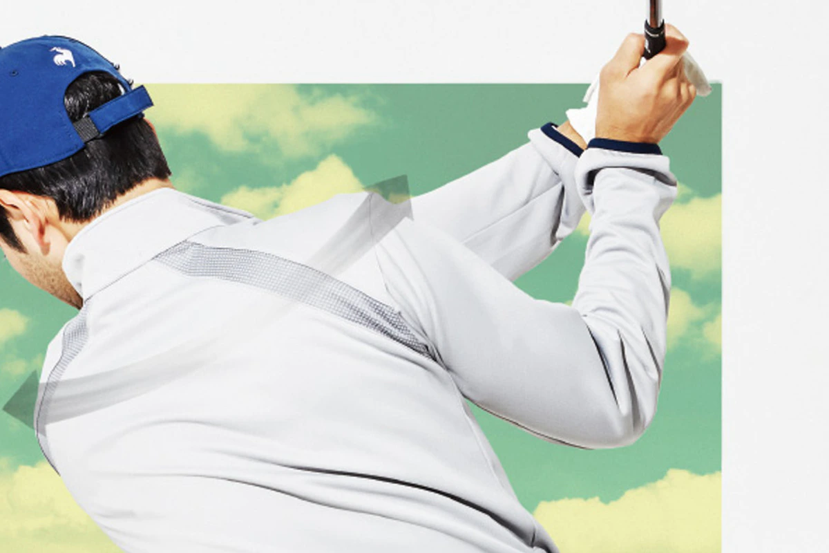 le coq sportif golfのウェアでスイングする男性ゴルファー